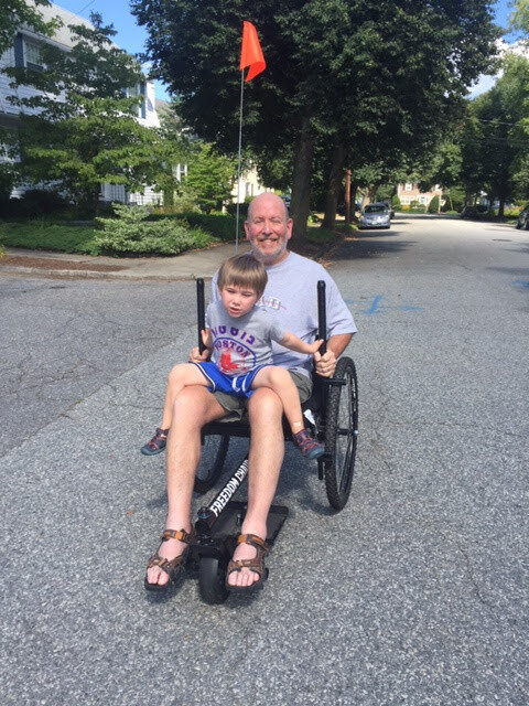 How Easy Is GRIT Freedom Chair To Push or Use for Seniors: senior Kenny uses GRIT Freedom Chair in neighborhood with grandchild on lap