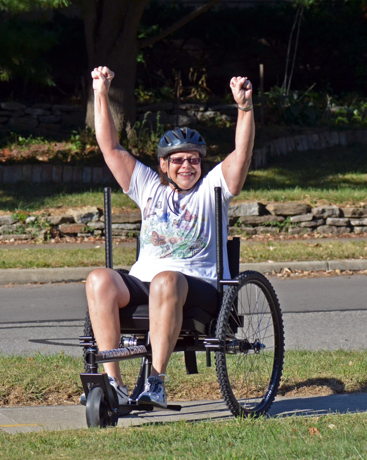 How Easy Is GRIT Freedom Chair To Push or Use for Seniors: senior GRIT Freedom Chair rider smiles with fists up using all terrain wheelchair