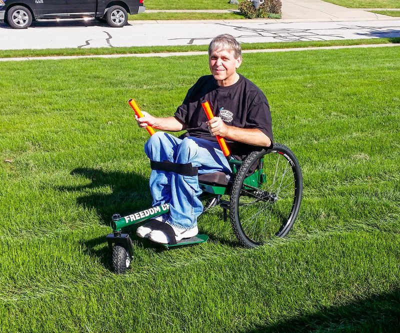 Getting to Know My GRIT Freedom Chair first outings: Brad trying all-terrain wheelchair in grass yard in neighborhood