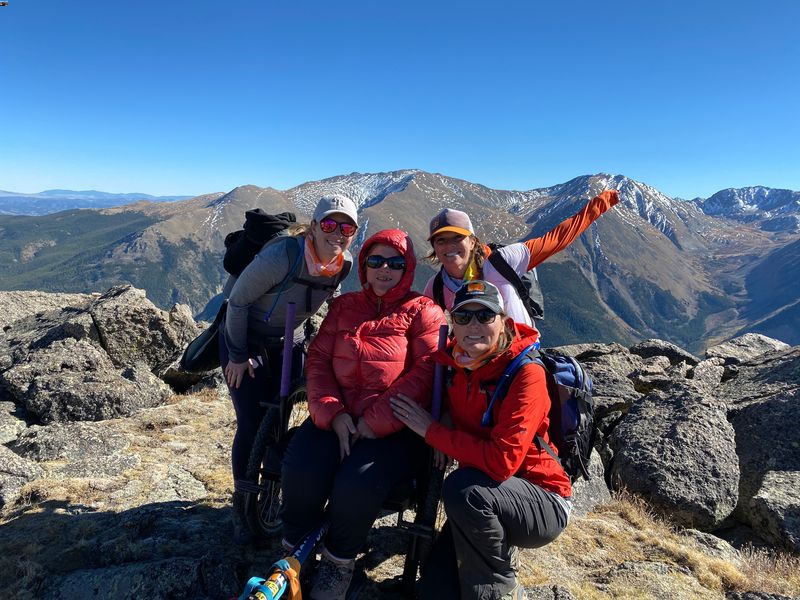 How To Ask for Personal Mobility Equipment Funding Help Step #2, Start the Conversation: team of 4 at hiking summit, 1 in GRIT Freedom Chair