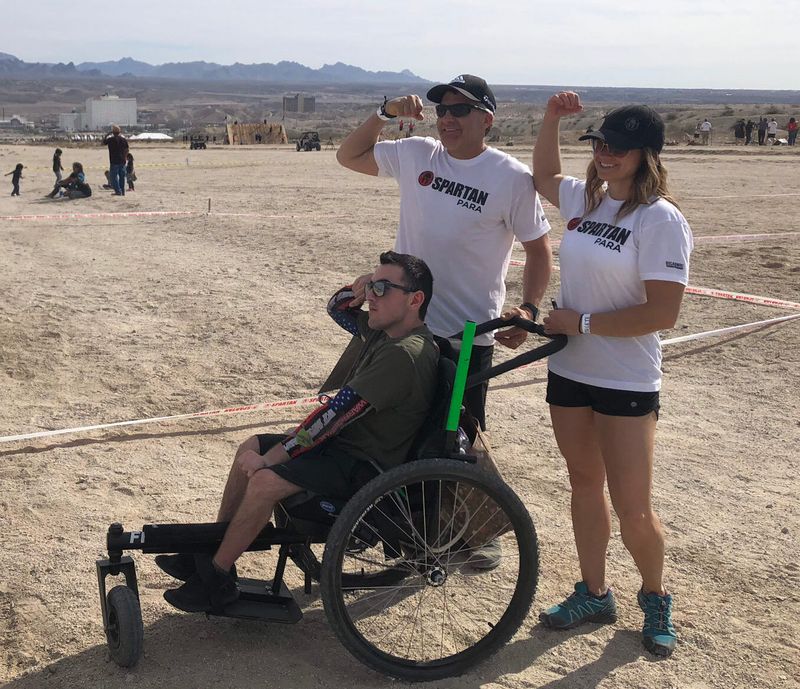 Trandon Mechling: Spartan, GRIT Athlete: Trandon and his parents flex their right arm muscles at the 2018 Para Spartan World Championships