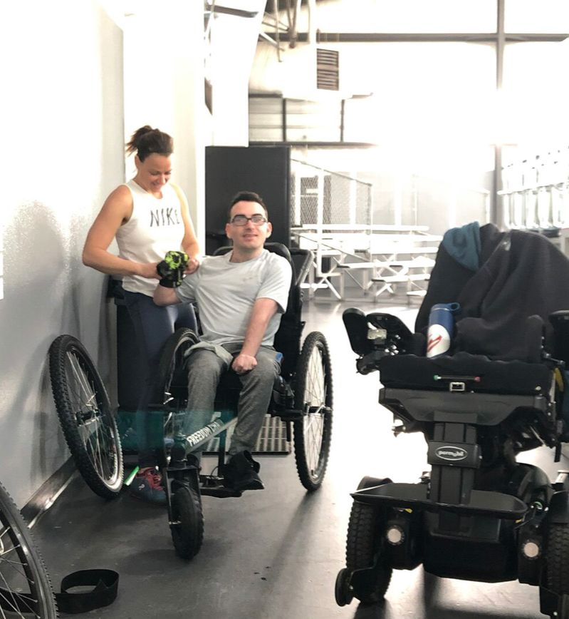 Trandon Mechling: Spartan, GRIT Athlete: Trandon smiles using GRIT Freedom Chair all-terrain wheelchair indoors with trainer